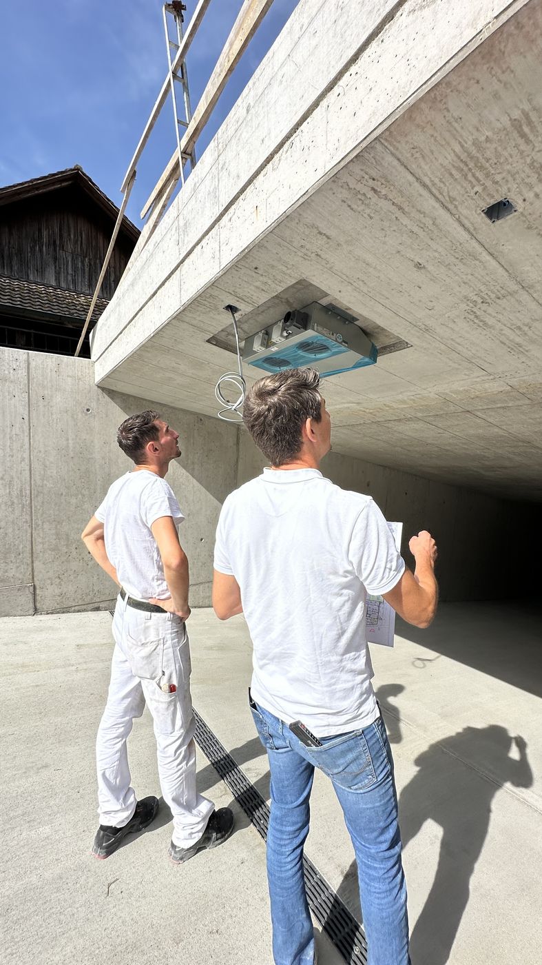 Zwei Mitarbeiter von Imo Malergeschäft beim Begutachten eines Betonvordachs