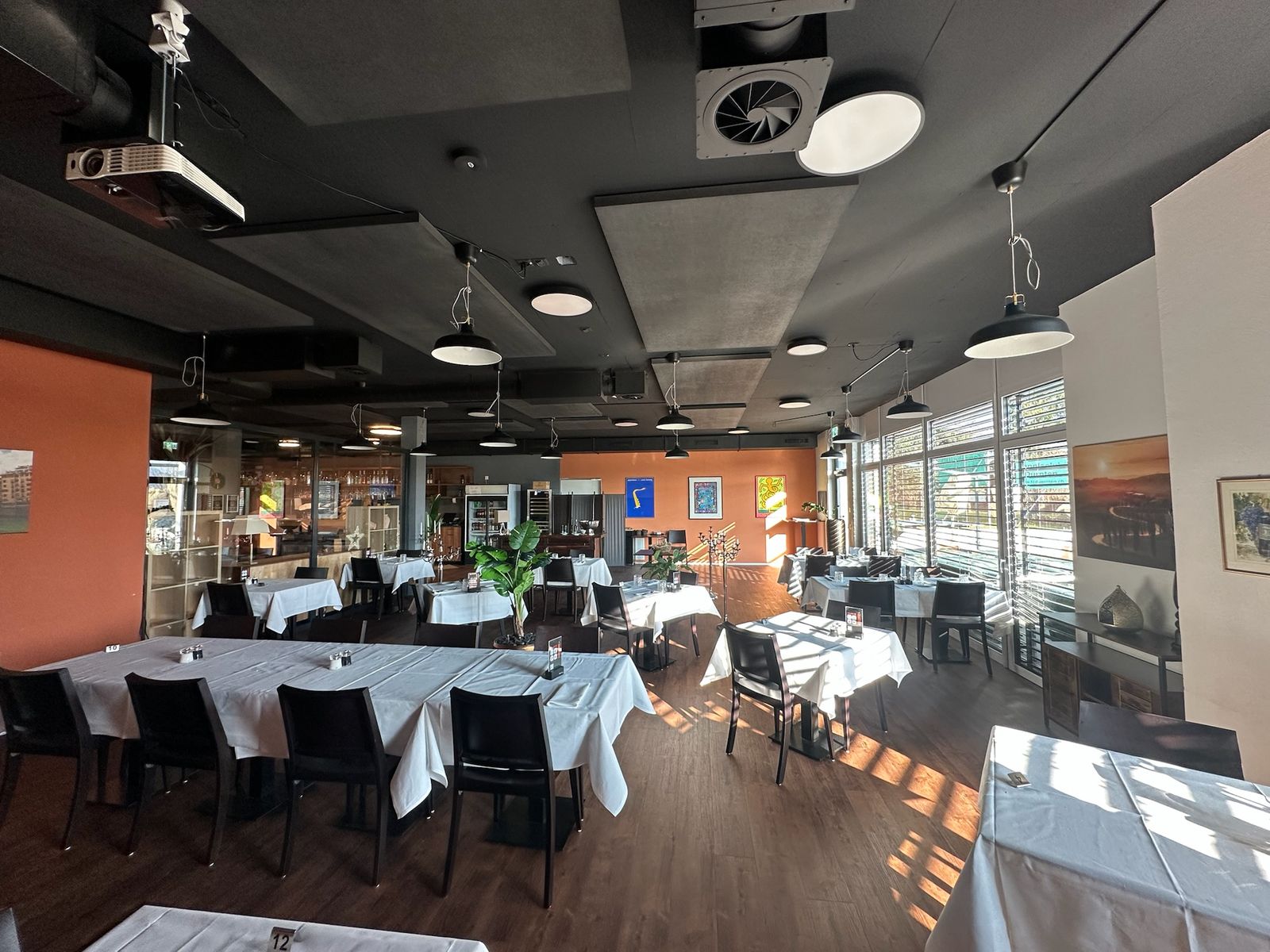 Restaurant mit orange gestrichener Wand und dunkler Decke