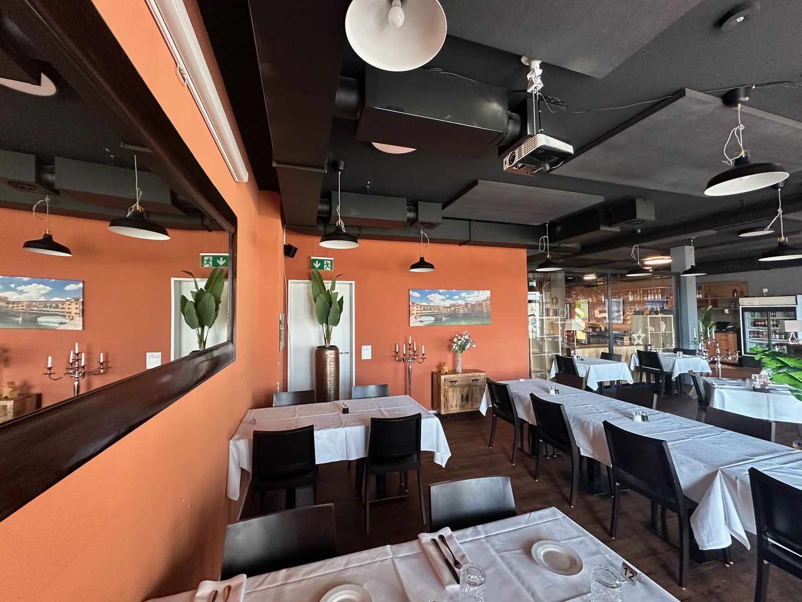 Restaurant mit orange gestrichener Wand und dunkler Decke